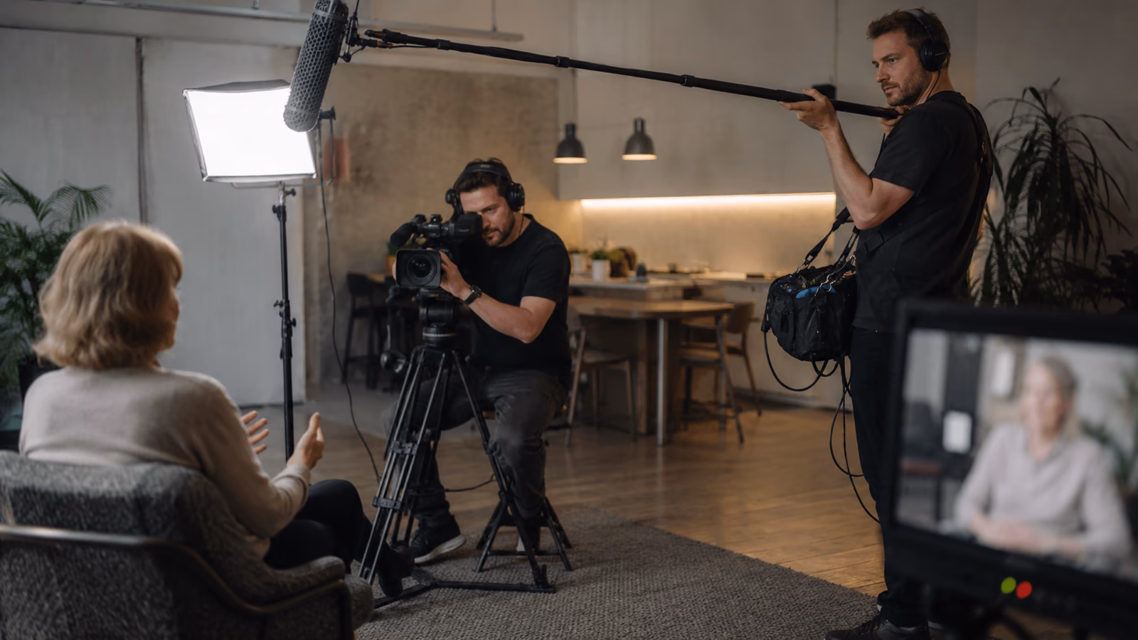 Équipe technique en tournage avec caméra et perche son lors d’une interview